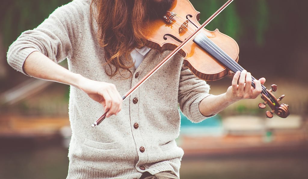 Female violin player in a flow state, focused on her music, representing the meditative states that enhance productivity and creativity.