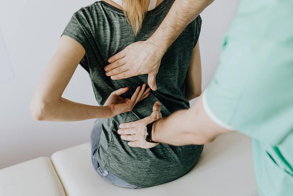 Doctor touching the back of a patient showing an inflamed area.